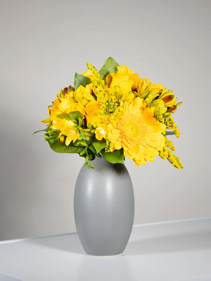 Bouquet giallo di rose e gerbere in vaso grigio